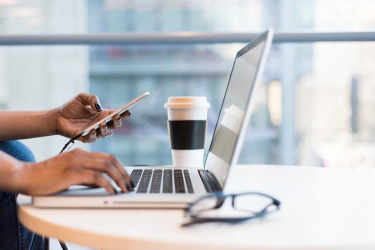 Woman using a phone and computer